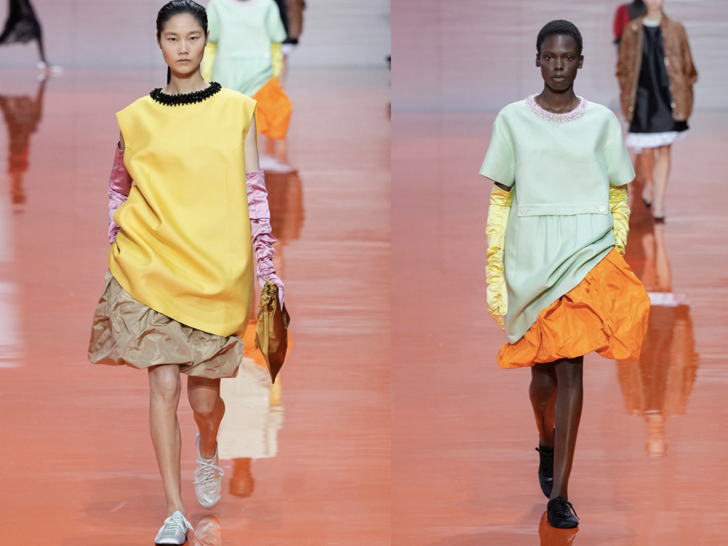 Modella in total look Prada SS26 con uniforme grigia e dettagli futuristi