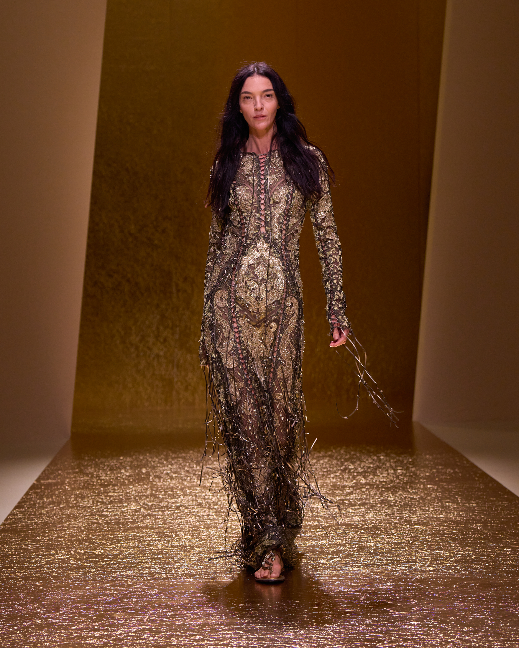 Modella Roberto Cavalli SS26 con abito dorato, stile sensuale e glamour provocante